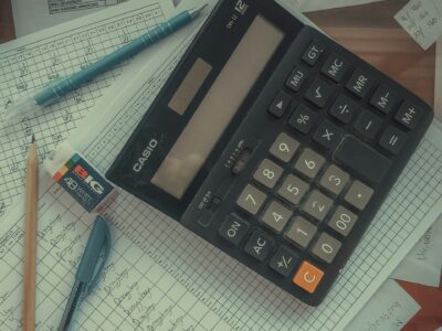 A digital calculator resting on paper accounting ledgers.